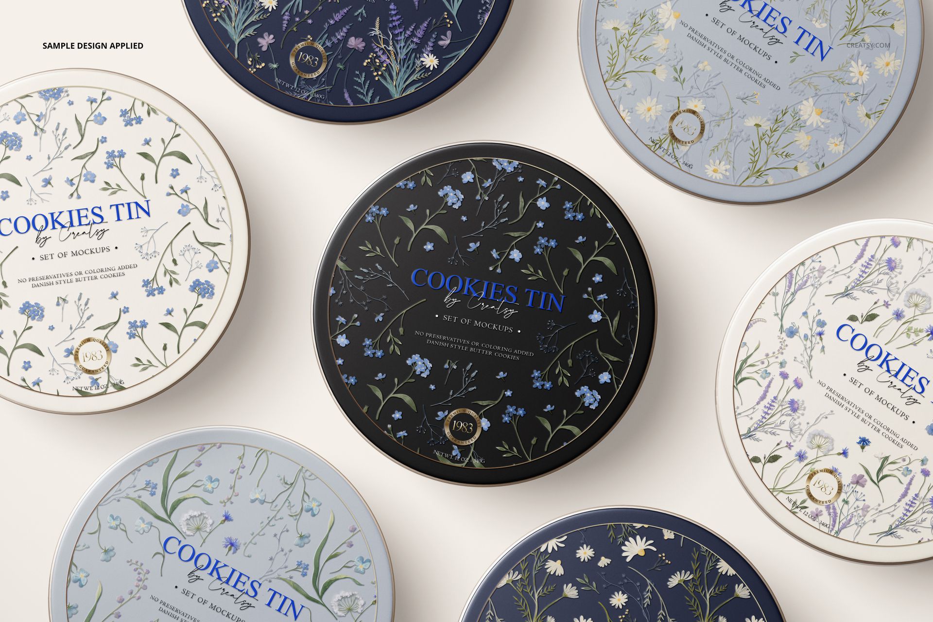 Round cookie tins with floral patterns arranged on a light surface, viewed from above in a mockup scene.