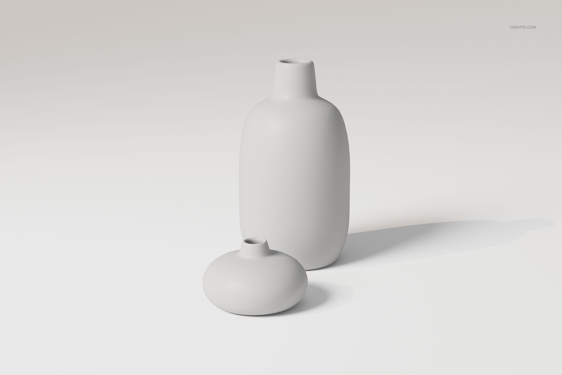 Two ceramic flower vases in matte white, one tall and cylindrical, one short and round, on a light surface.