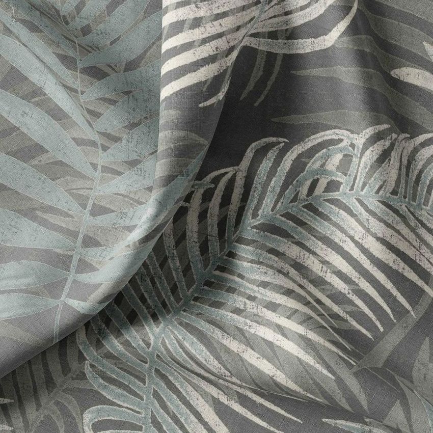 Fabric tester mockup showing draped textile with a large-scale botanical leaf pattern in muted gray, blue, and cream tones.