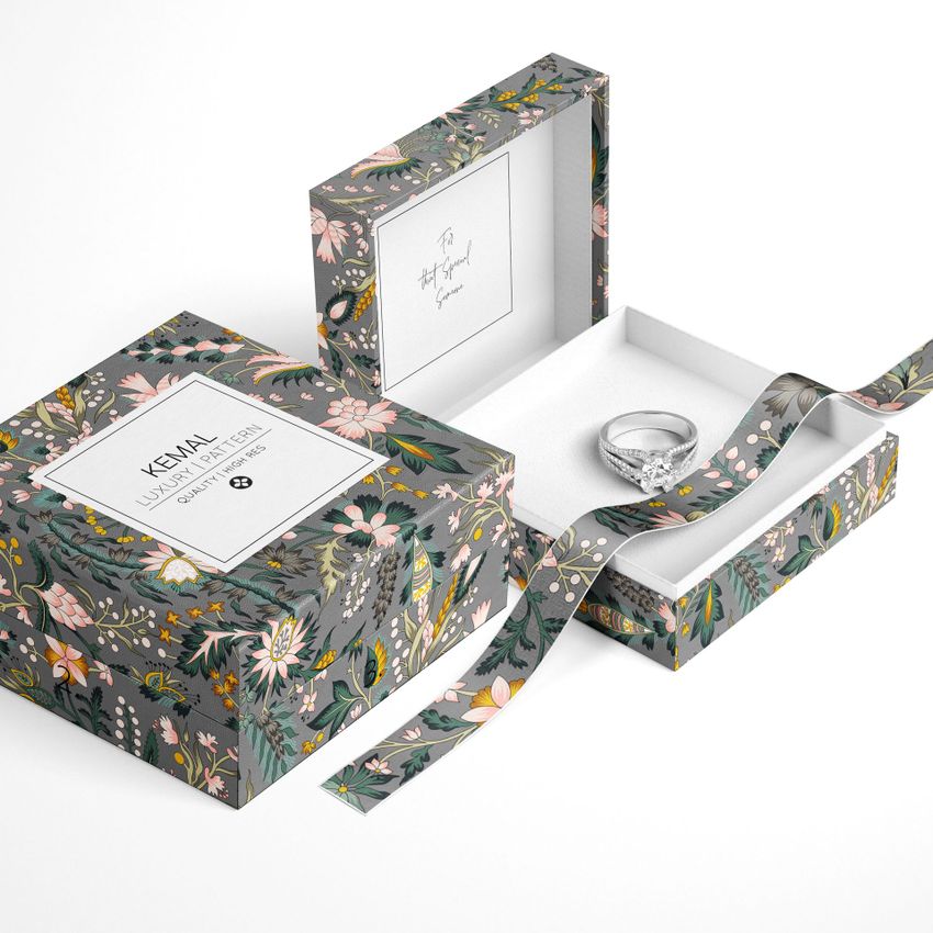 Jewelry box mockup featuring a floral pattern on a gray background, with an open lid revealing a ring inside on white padding.