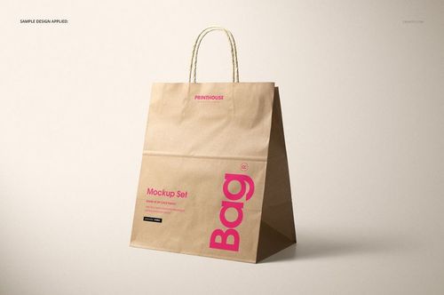 Brown kraft paper shopping bag mockup featuring rope handles and visible printed sample design, angled side view.
