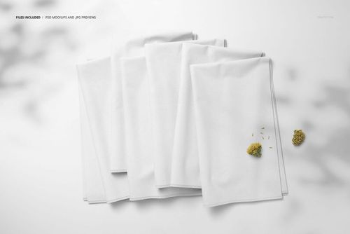 Fabric stack mockup showing multiple white cloths folded together on a light background, top perspective with floral props.