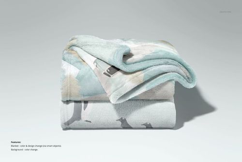 PSD mockup of a folded fleece blanket with subtle woodland design, photographed from a straight-on perspective.