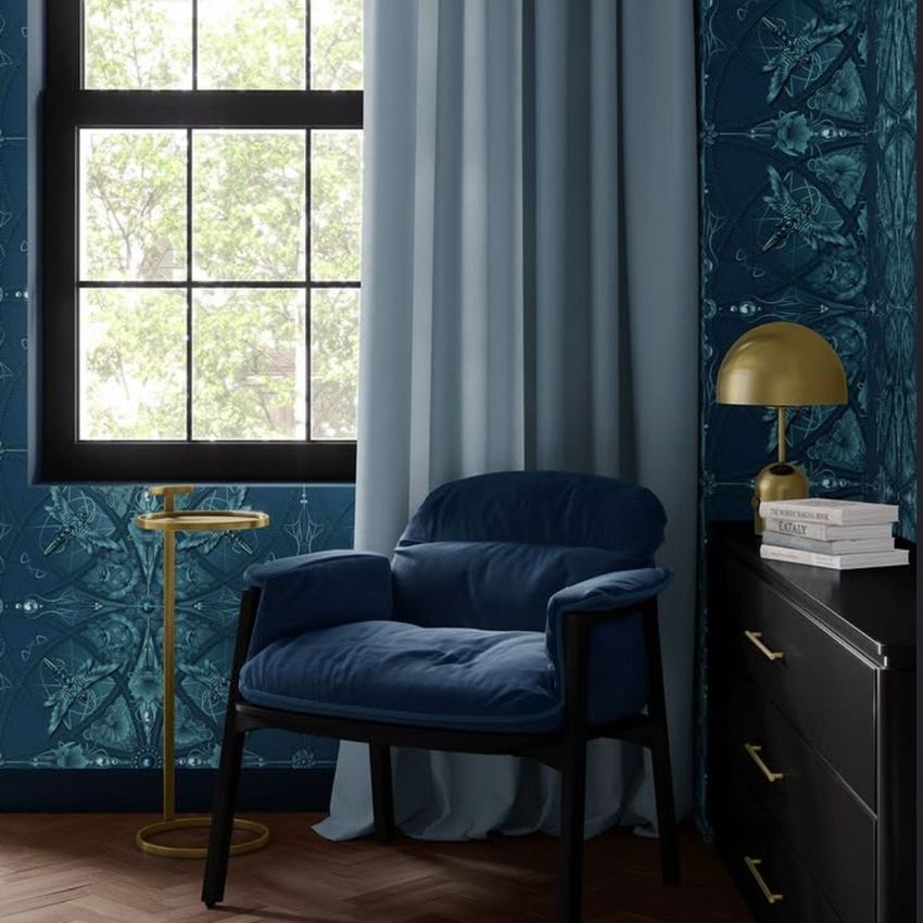 Lounge corner chair mockup scene featuring a blue velvet chair near a window with sheer curtains and patterned wallpaper.