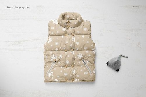 Boys winter set mockup featuring a beige padded vest with snowflake design and a gray hat, shown from above on a wooden background.