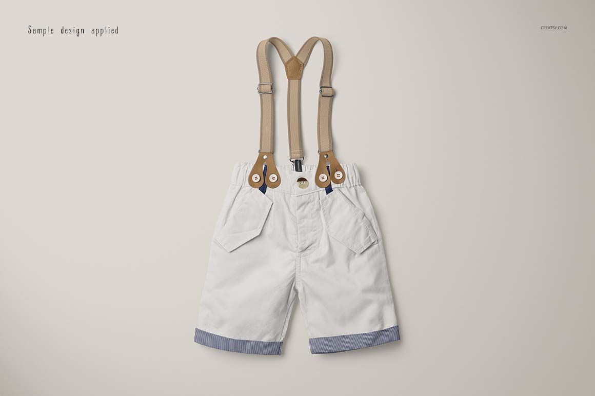 Boys formal set mockup showing white shorts with tan suspenders and blue striped trim, displayed flat on light surface.