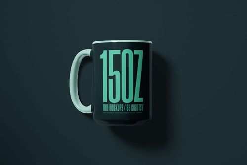 Front view of a black 15oz mug with large turquoise text, shown on a dark background in a mockup scene.