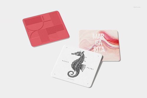 Square coaster mockup with red, marble, and seahorse artwork, displayed in a scattered layout against a neutral surface.