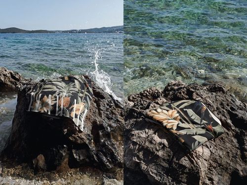 Tropical patterned waffle towel mockup shown on rocks near the sea, with waves splashing and scenic background.