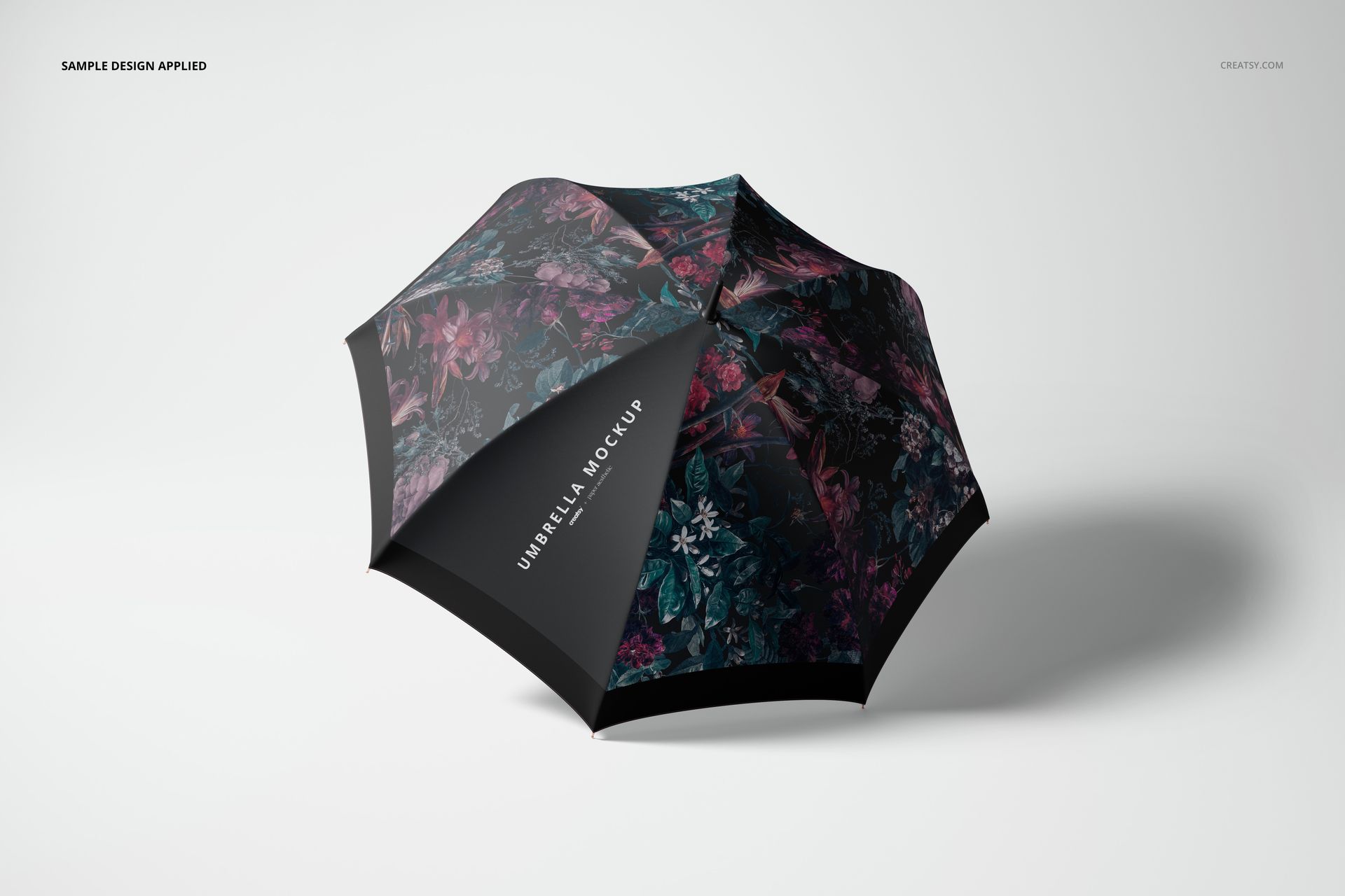 Open umbrella with dark floral pattern, viewed from above at an angle on a light background, fashion accessory mockup.