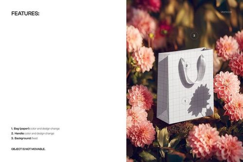 Front view of a paper shopping bag mockup with grid pattern, placed among pink flowers and green leaves outdoors.