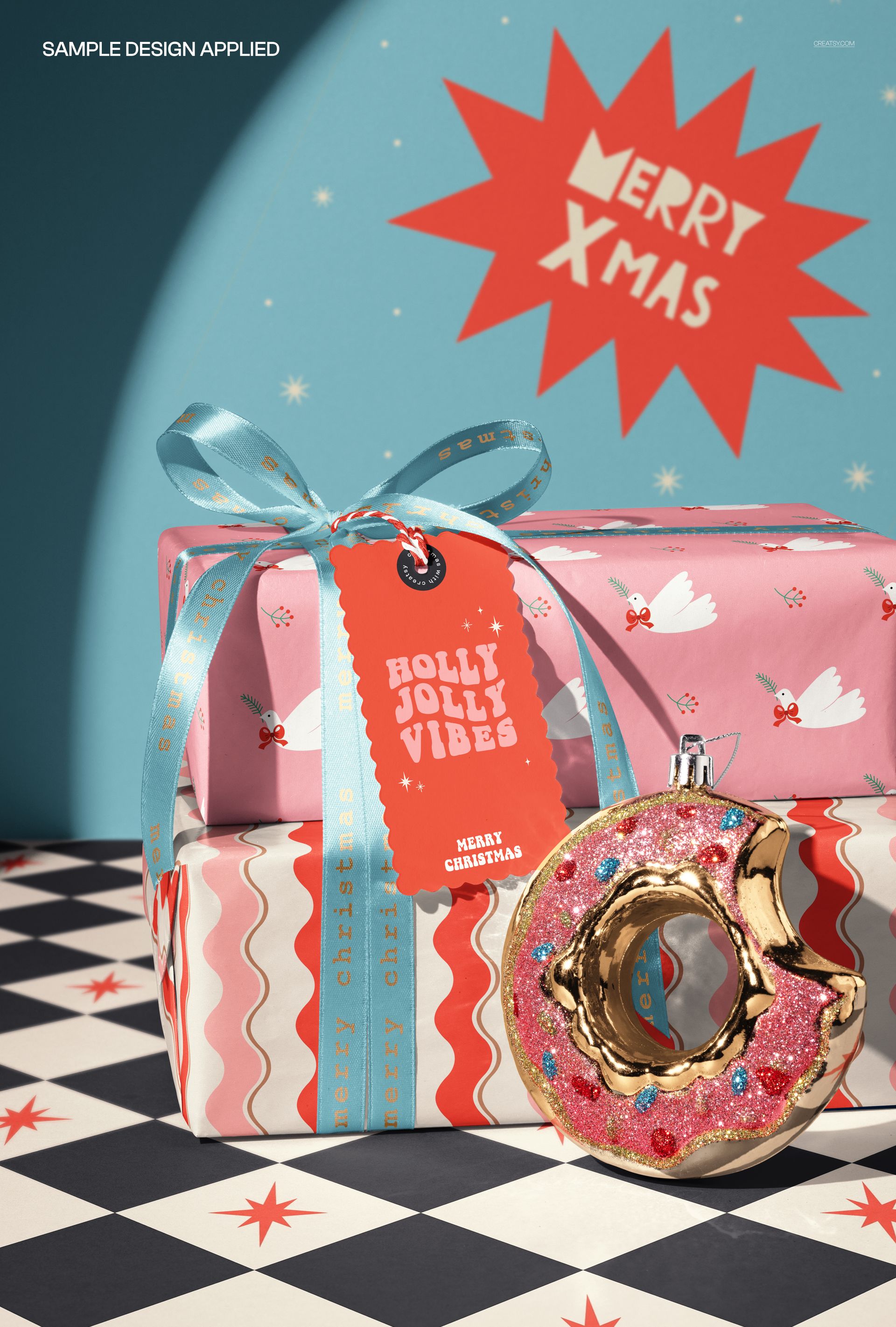 PSD mockup showing two wrapped gift boxes with decorative tags and a pink donut ornament on patterned floor.