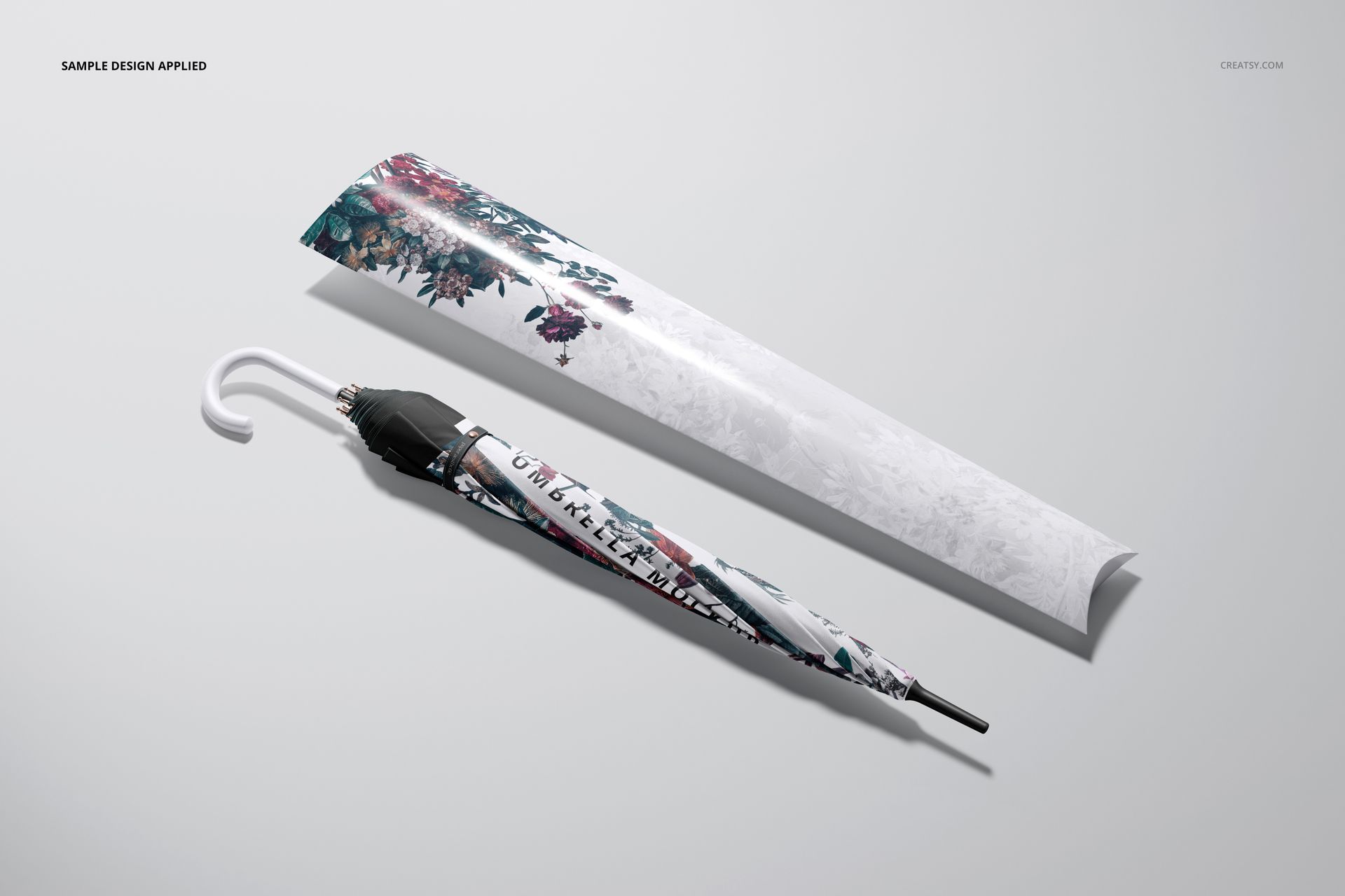 Umbrella mockup featuring a folded umbrella with floral print and coordinating packaging sleeve in top view.