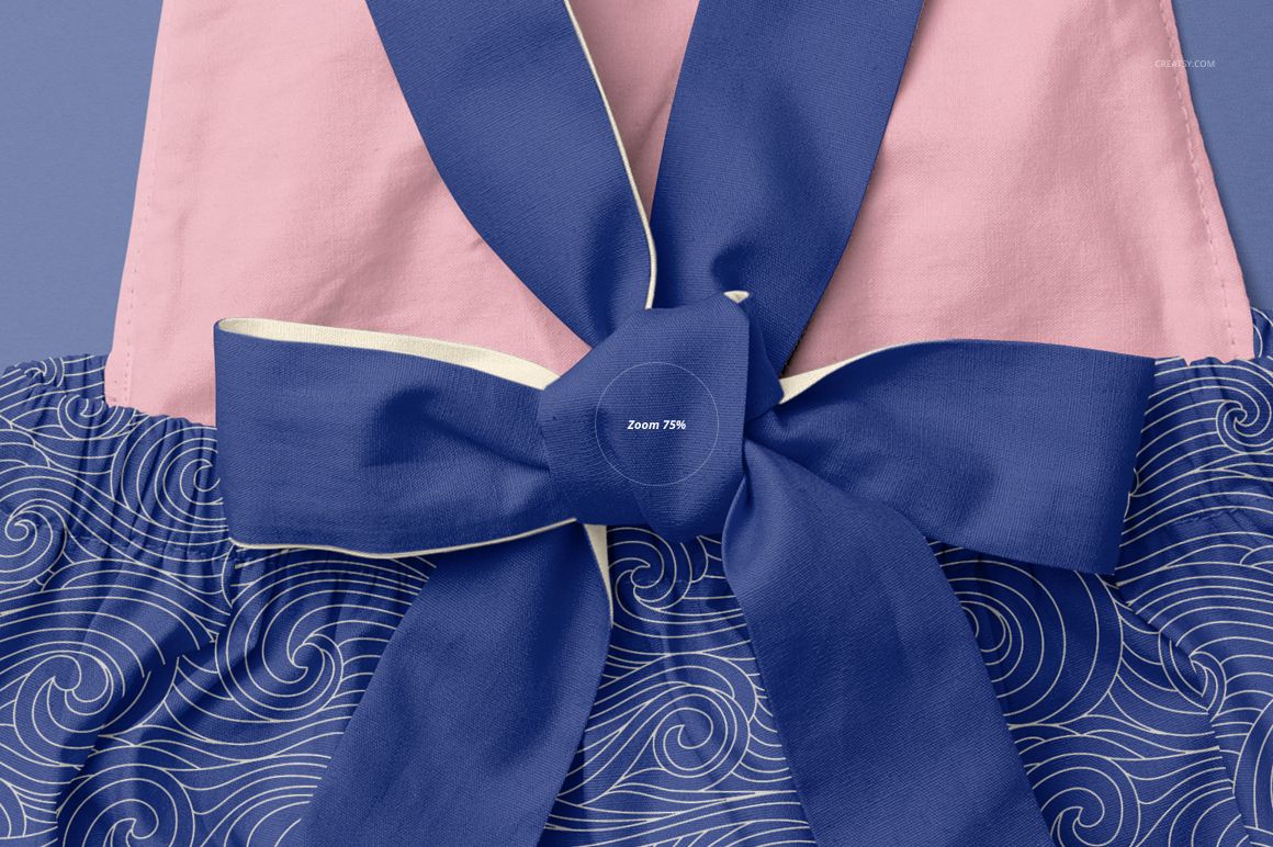 Close-up front view of a baby romper mockup featuring a large blue bow, pink top section, and blue wave-patterned bottom.