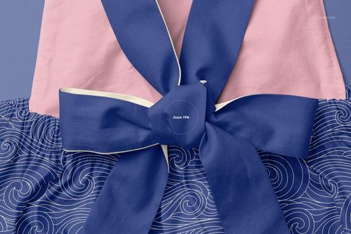 Close-up front view of a baby romper mockup featuring a large blue bow, pink top section, and blue wave-patterned bottom.