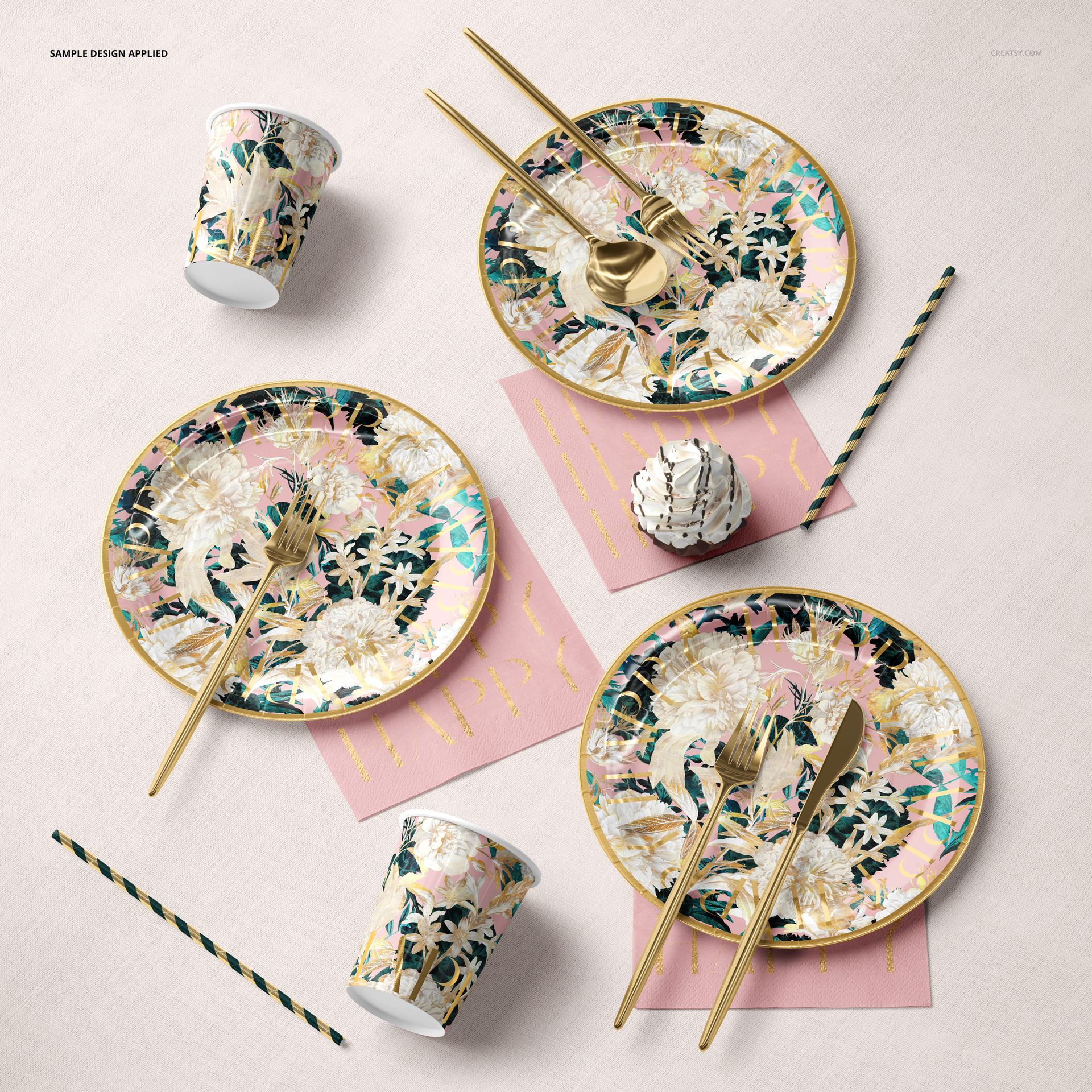 Party paper tableware set mockup featuring floral patterned plates, cups, and gold utensils on a light surface.