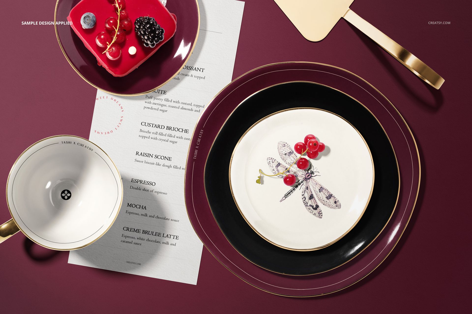 Top view of a plate mockup set with pastry items, featuring white plates with gold rims and a dragonfly design.
