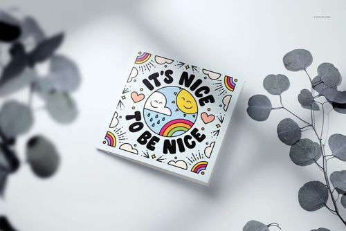 Square greeting card mockup featuring colorful artwork with rainbows, hearts, clouds, and a sun on a light surface.