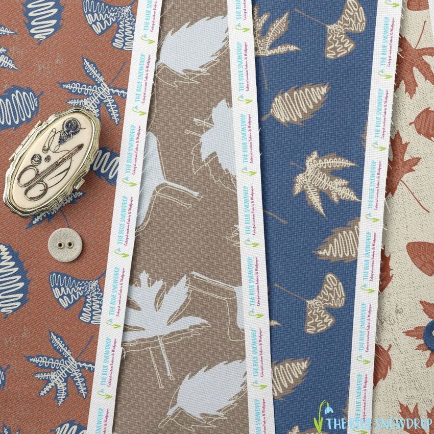Cotton fabric sample mockup showing three patterned fabric strips with leaf motifs in brown, blue, and orange tones on a flat surface.