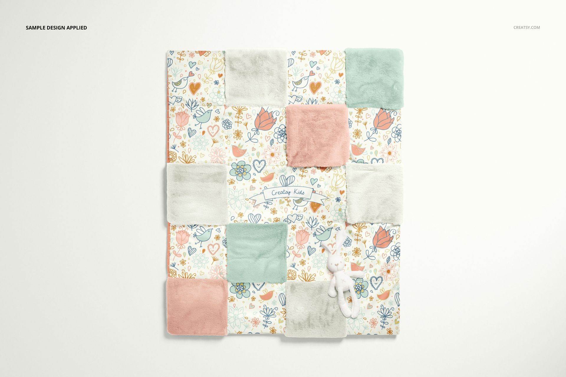 Baby patchwork quilt mockup with soft fleece squares in pink, mint, and beige, arranged alongside playful floral prints.