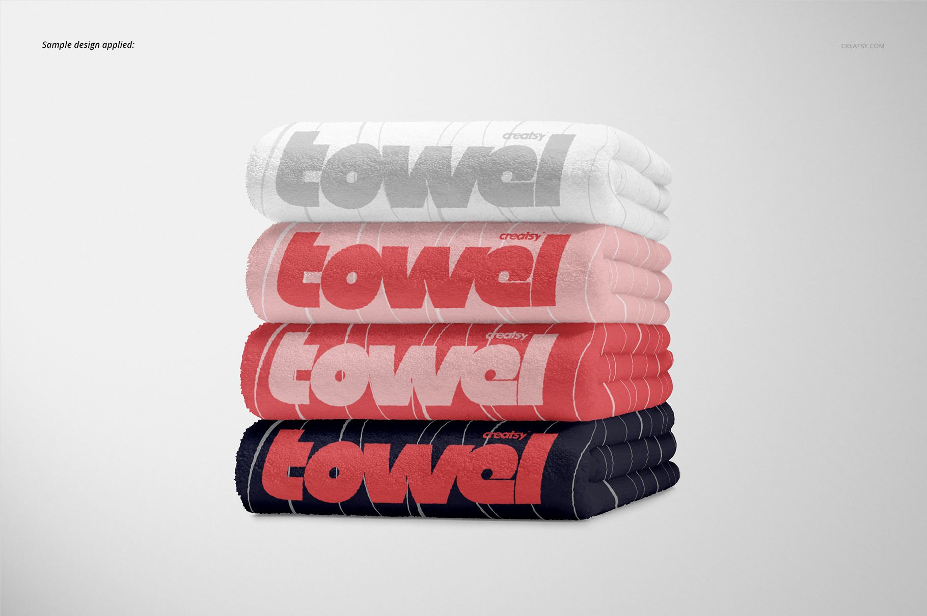 Stack of four towels in white, gray, pink, and navy colors with bold text design, shown in a front view mockup.