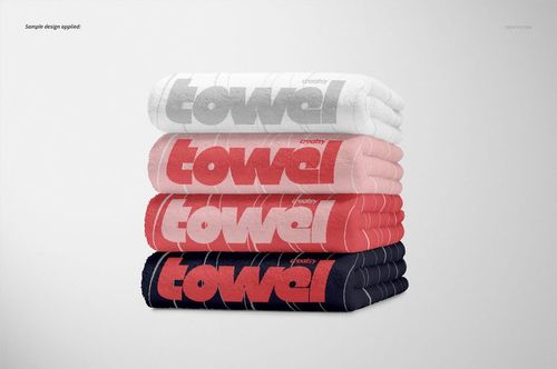 Stack of four towels in white, gray, pink, and navy colors with bold text design, shown in a front view mockup.