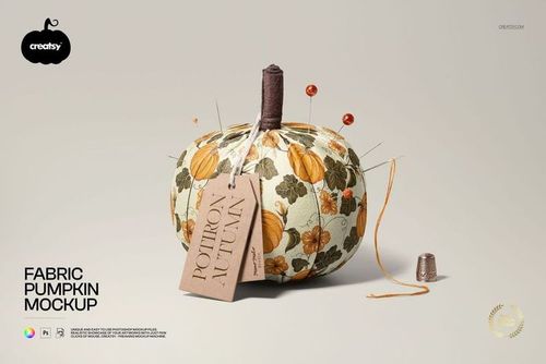 Front view of a fabric pumpkin mockup with floral and pumpkin patterns, sewing pins, thread spool, and a label tag.