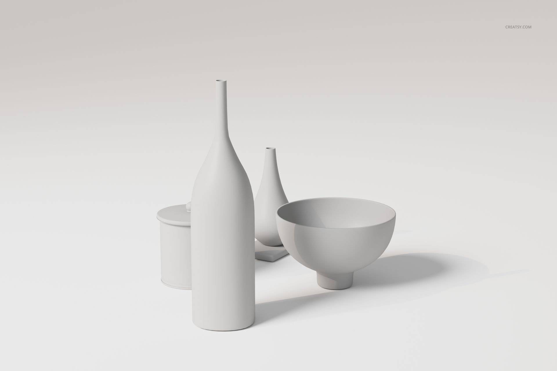 Set of modern ceramic vases and bowls in matte white finish, arranged on a light surface with soft shadows.