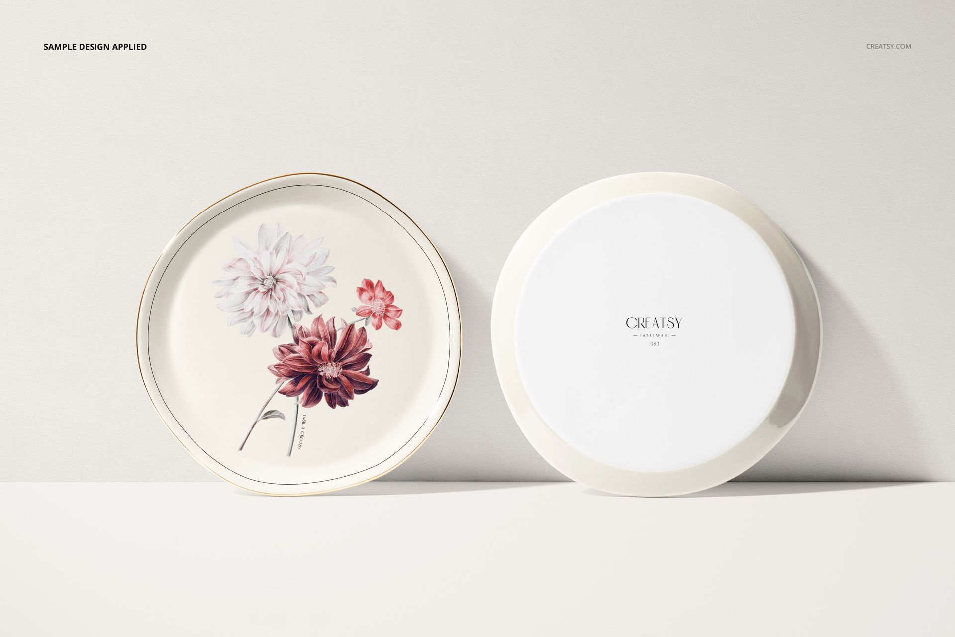 Two round plates on a light surface, one with floral artwork and one plain, shown in a front-facing mockup scene.