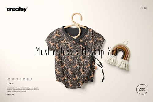 Muslin onesie mockup featuring a dark floral design, displayed on a hanger beside a woven rainbow ornament.