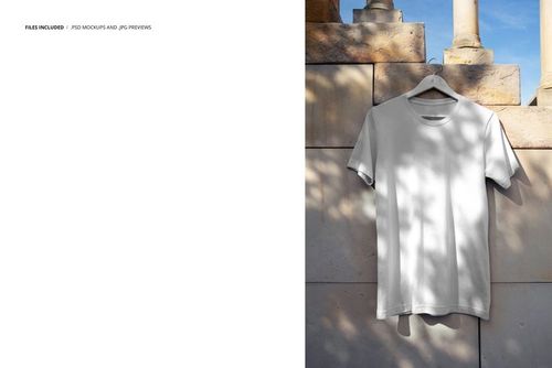 Plain white t-shirt displayed on a hanger in front of a textured stone wall, sunlight casting soft shadows, PSD mockup.