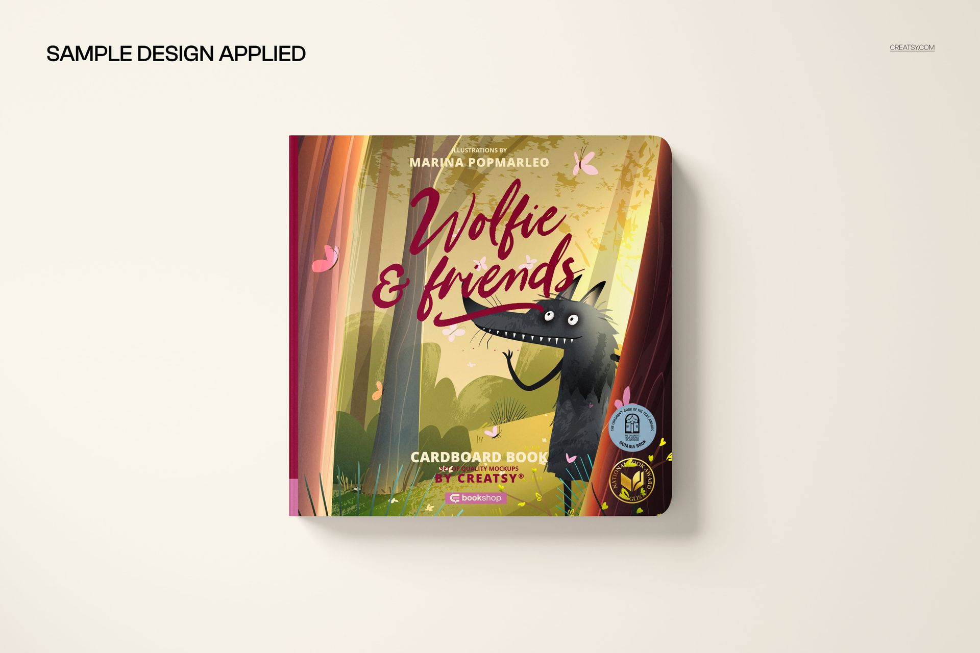 Cardboard baby book mockup showing a vibrant cover design with a cartoon wolf and trees, viewed from above.