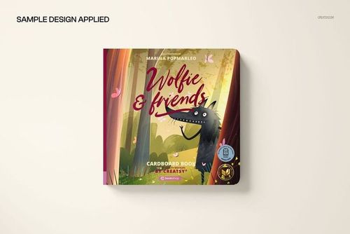 Cardboard baby book mockup showing a vibrant cover design with a cartoon wolf and trees, viewed from above.