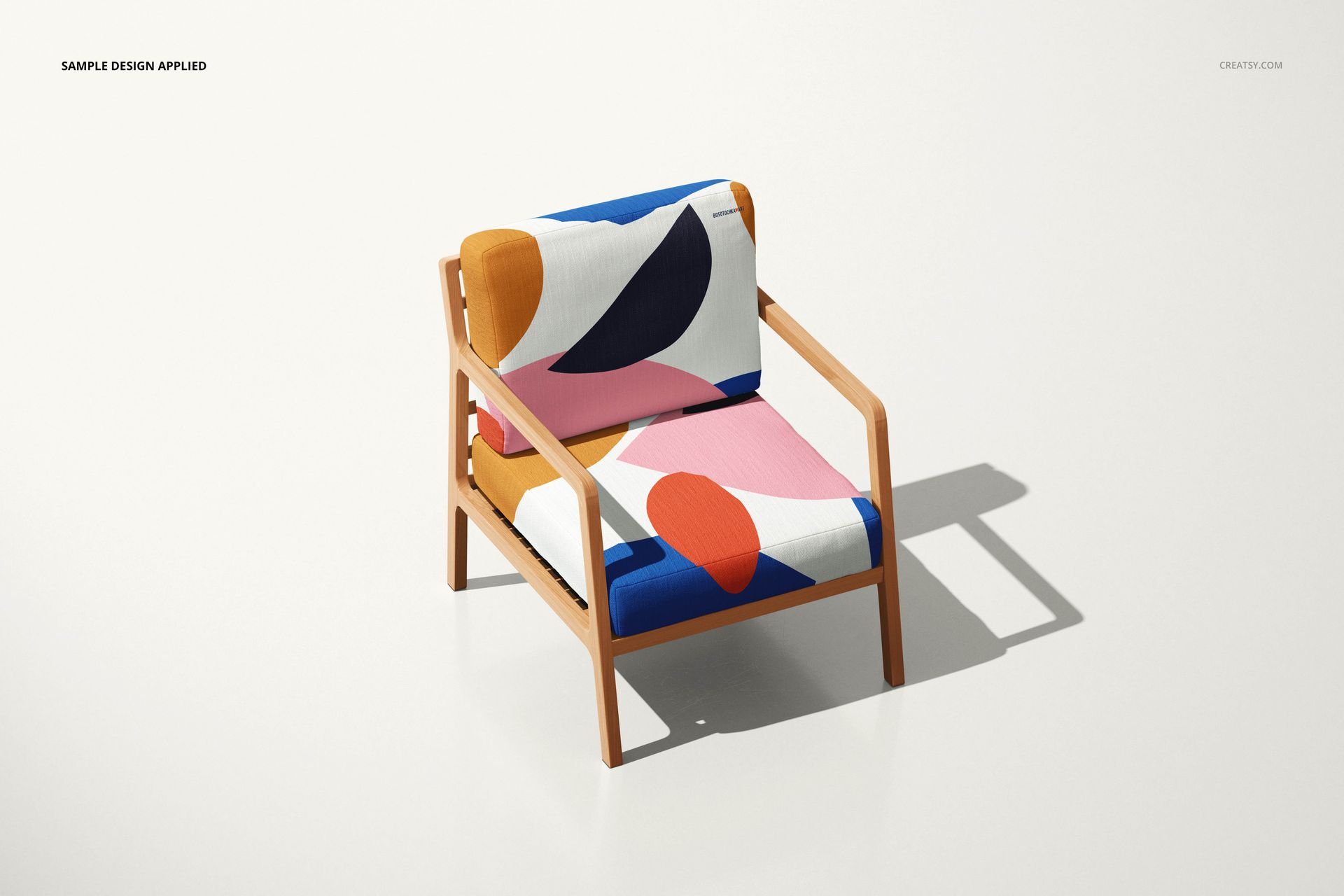 Lounge chair mockup with light wood structure, upholstered in vibrant geometric fabric, shown from a front side perspective.