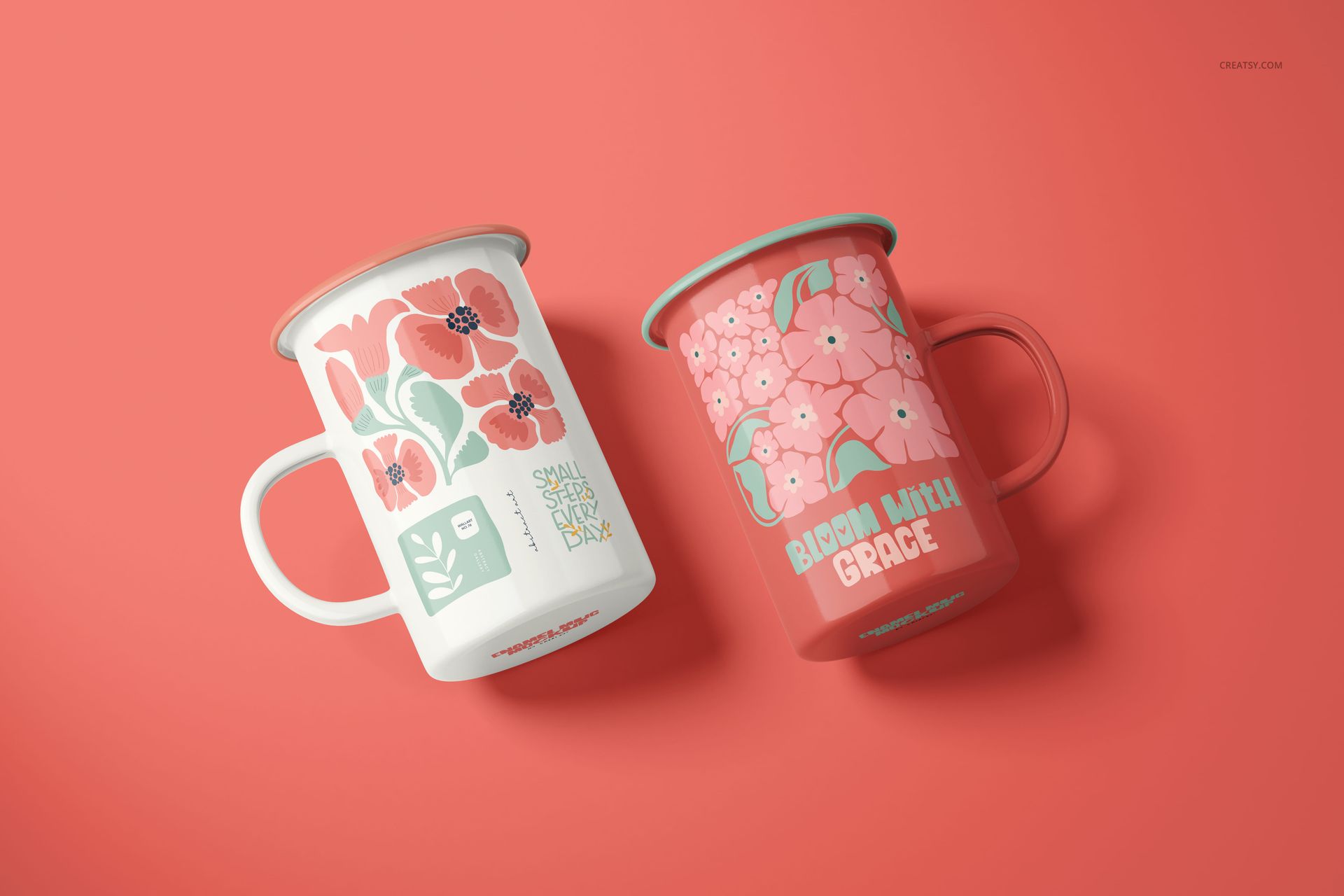 PSD mockup of enamel mugs with botanical prints, one in white and one in coral, arranged side by side.