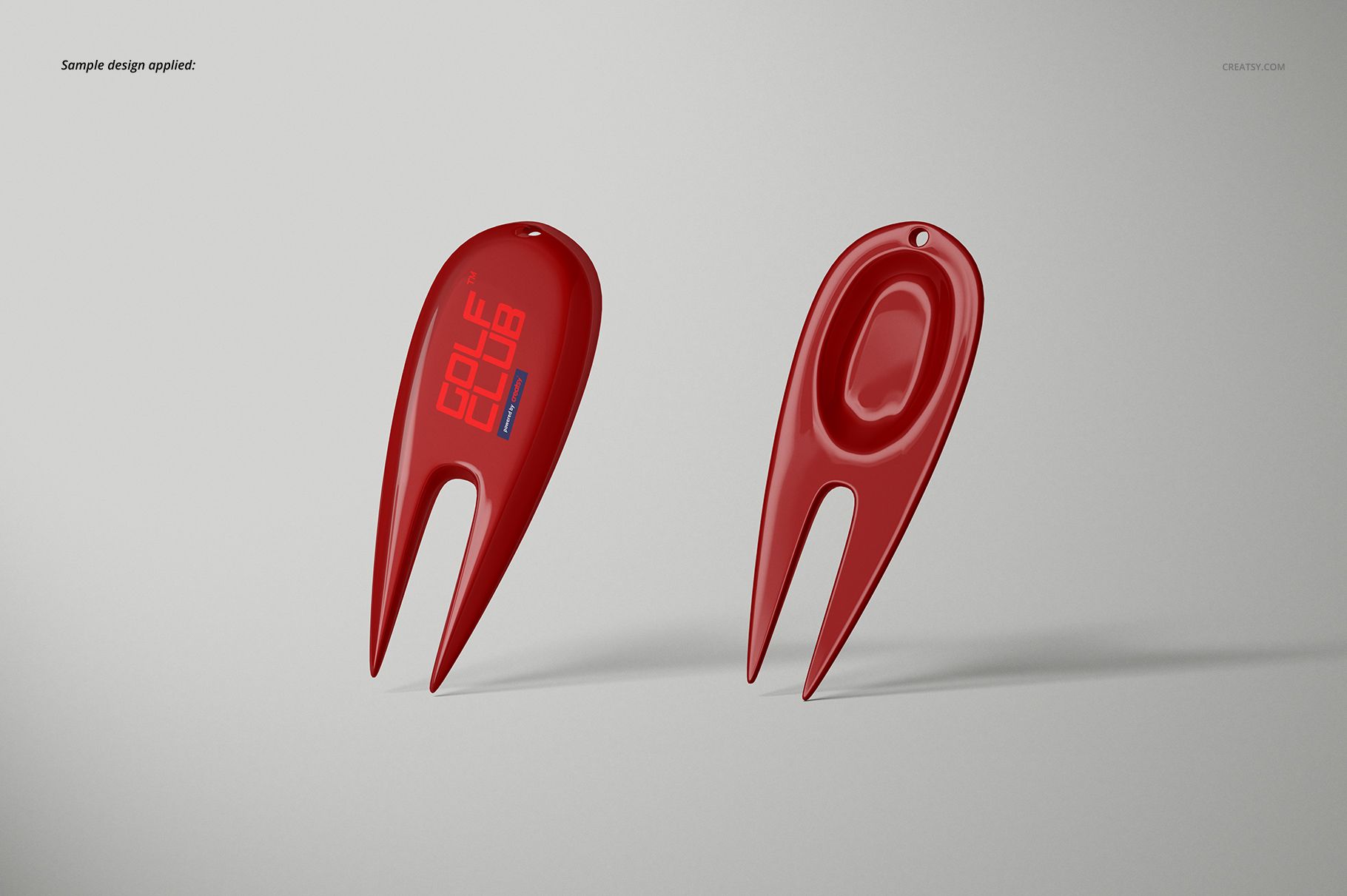 Two red golf divot tools displayed on a light gray background, shown from front and back angles with smooth surfaces.