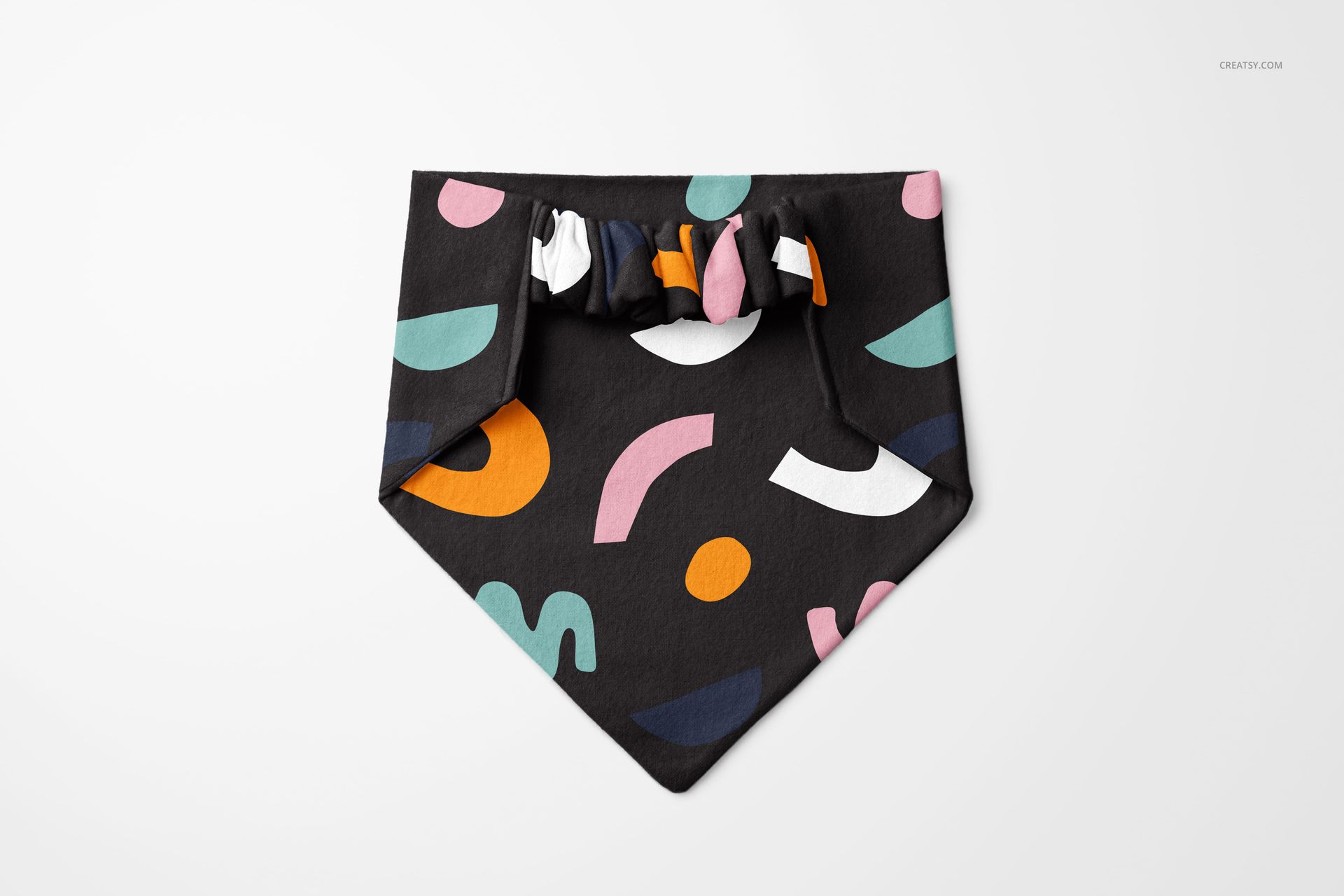 PSD mockup showing a pet bandana and scrunchie set with bold abstract shapes in pink, orange, green, and white.