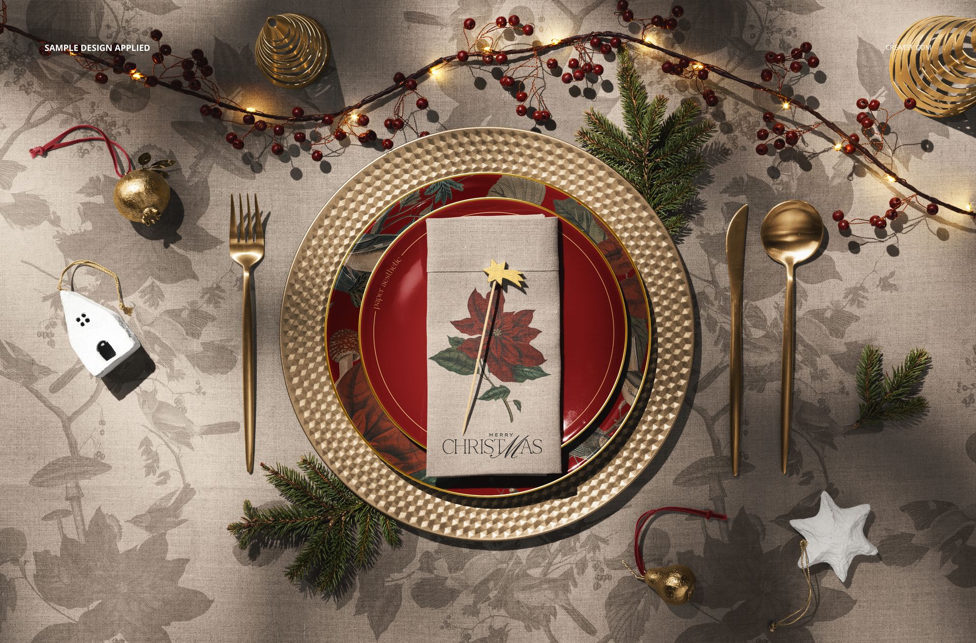 Top view of a Christmas tableware set mockup featuring patterned plates, gold utensils, and seasonal decor.