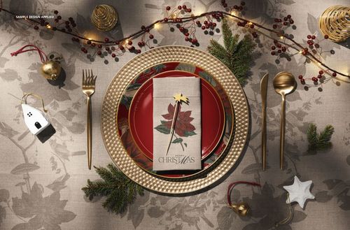 Top view of a Christmas tableware set mockup featuring patterned plates, gold utensils, and seasonal decor.