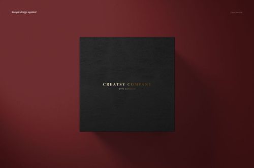 Black square cufflinks box with gold and white text, centered on a dark red background, top view mockup.