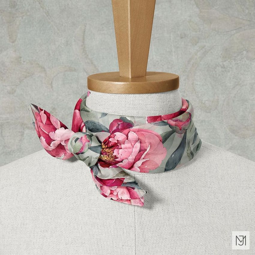 Silk scarf mockup featuring a floral pattern with pink peonies, styled on a mannequin with a wooden neck stand against a textured backdrop.
