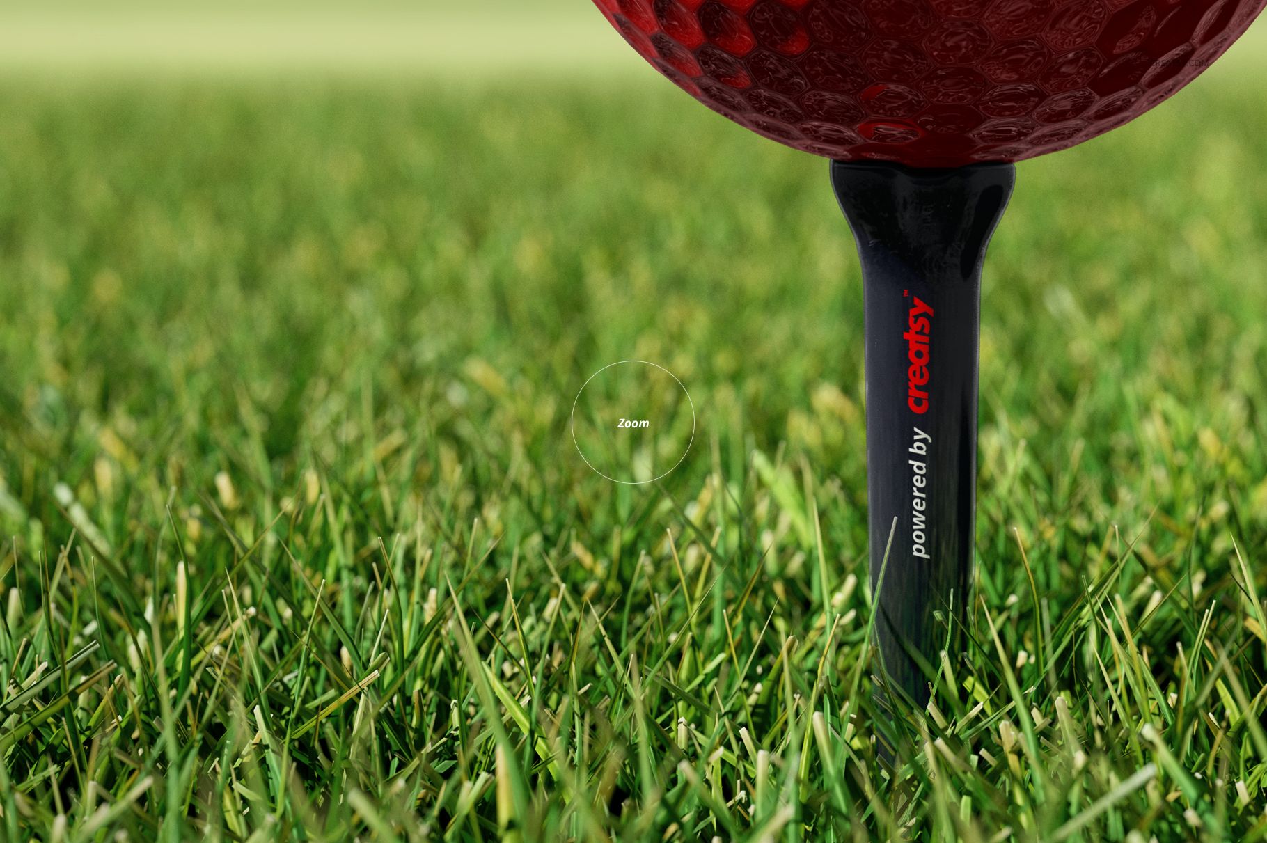 Detailed mockup showing a textured red golf ball on a black tee, positioned in vibrant green grass from a low angle.