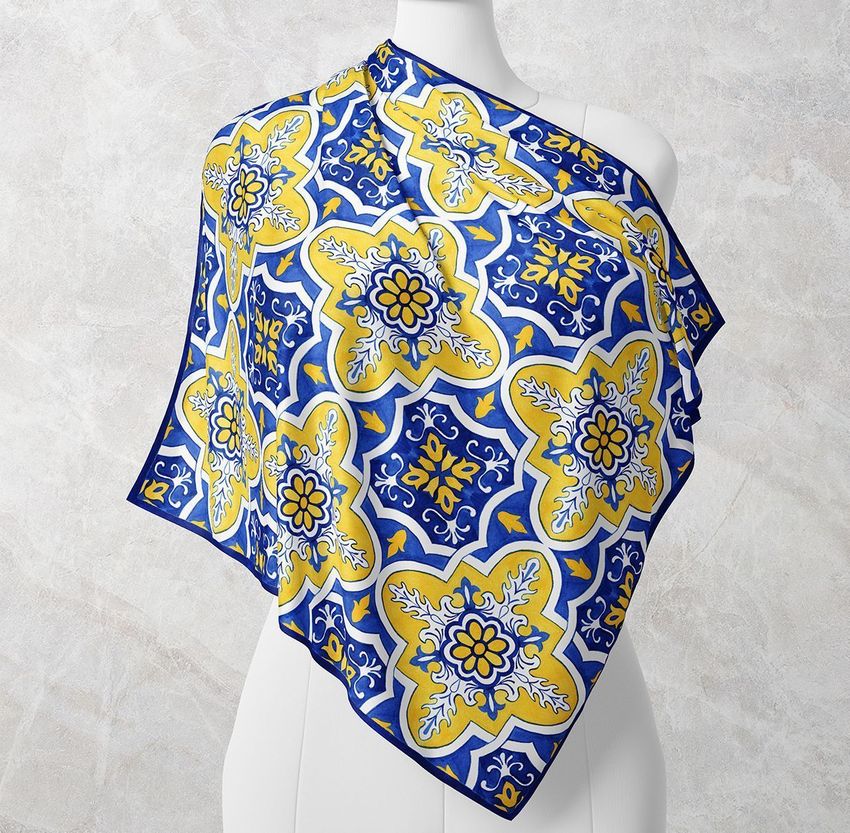 Wrapped silk scarf mockup displayed on a white mannequin, featuring a blue and yellow azulejo tile pattern against a light textured background.