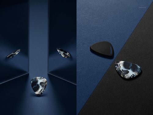 Guitar pick mockup set featuring two picks with abstract patterns, dramatic shadows, and mirrored reflections on dark surfaces.