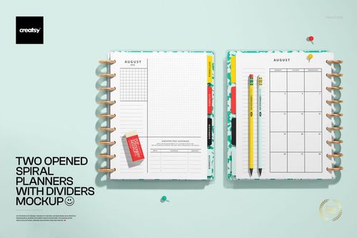 Mockup of two open spiral-bound planners with divider tabs, pencils, and push pins arranged on a light blue desk.