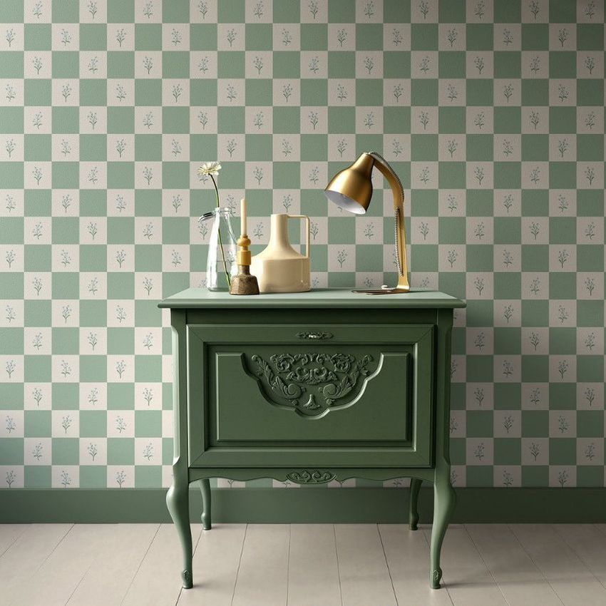 Interior scene mockup showing a vintage green nightstand against a checkered floral wallpaper, with a gold lamp and decorative vases on top.