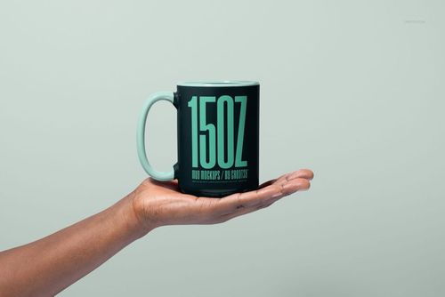 PSD mockup of a large mug in black and mint green, held in a palm, with minimalist background and clear text details.