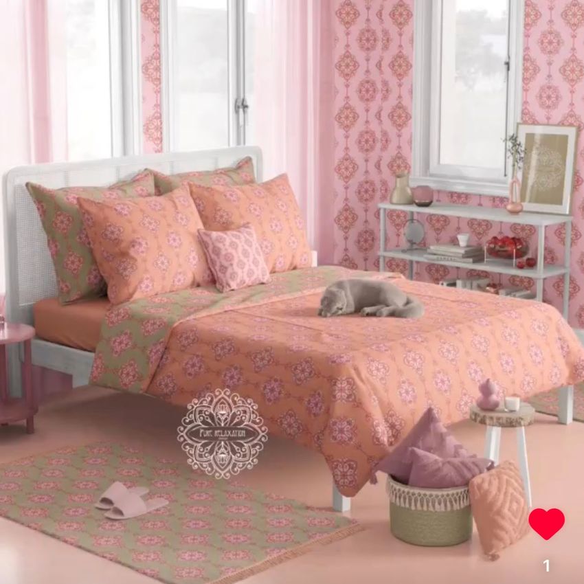Boho bedroom bedding mockup featuring a pink and orange mandala patterned comforter, pillows, and rug in a softly lit room.