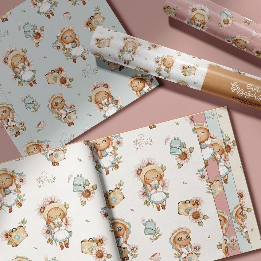 Wallpaper sample book mockup featuring open pages with whimsical bunny illustrations, floral patterns, and pastel colors.