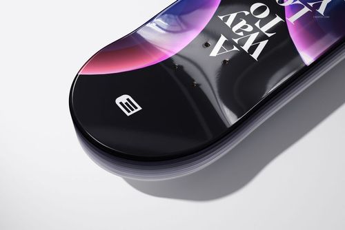 Close-up view of a clear epoxy resin coated skateboard deck mockup with abstract purple and pink patterns on a white surface.